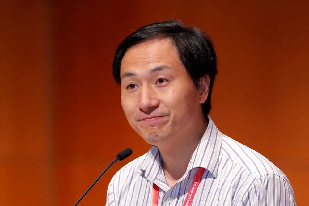 Photo of He Jiankui in front of a microphone