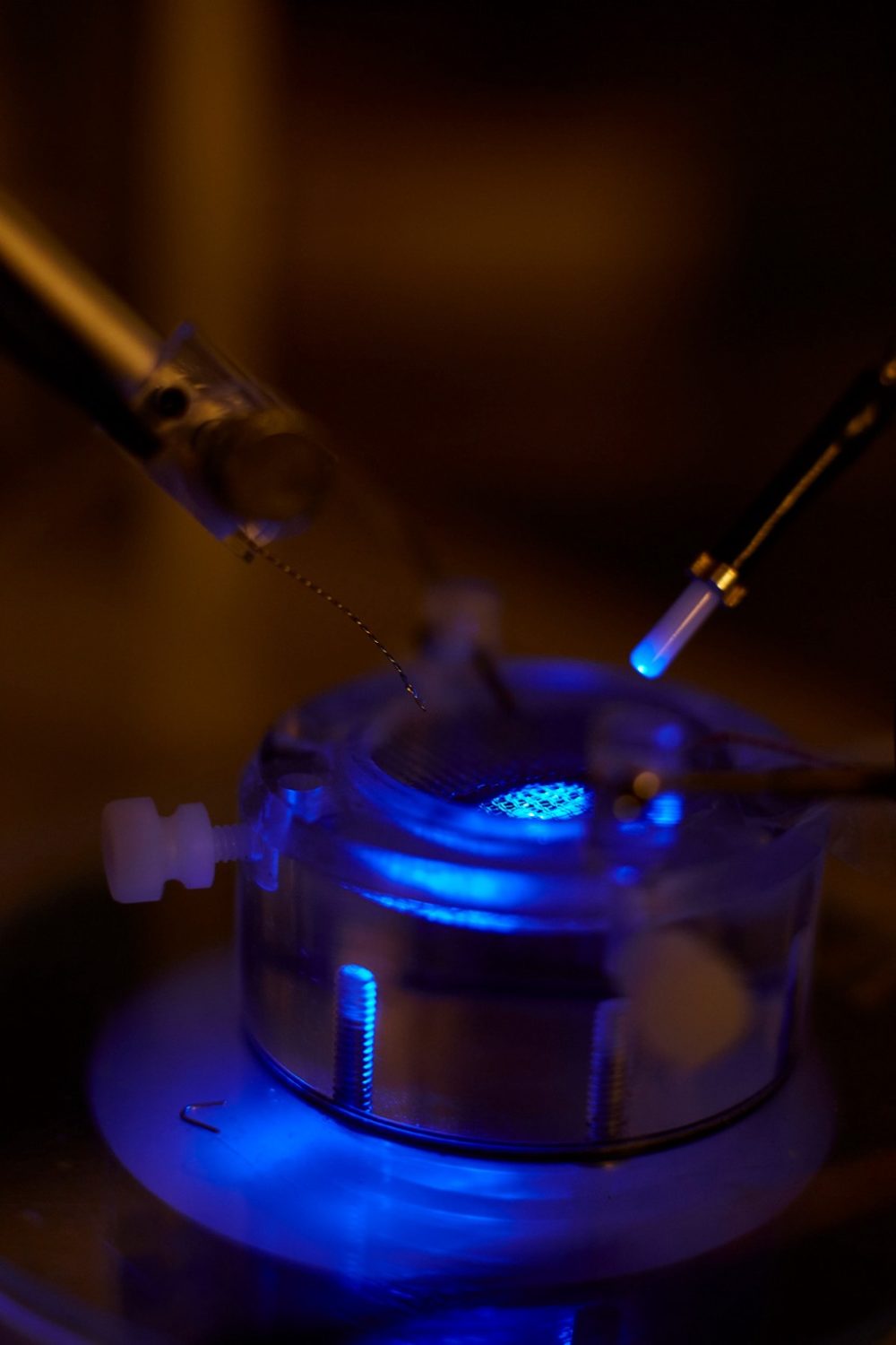 Round metal cylinder with a blue light shining in the middle.