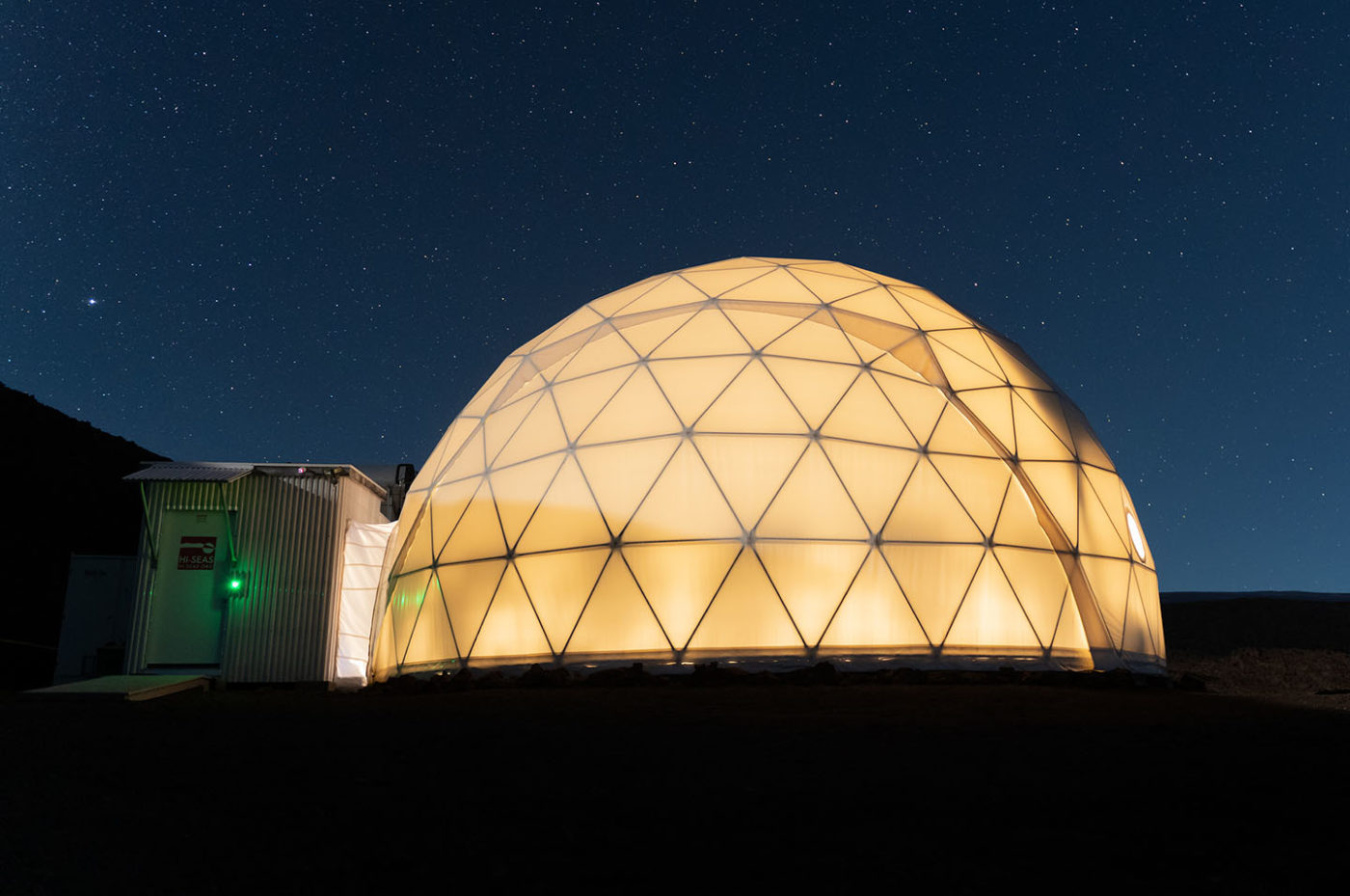 A photograph of a large dome glowing at night.