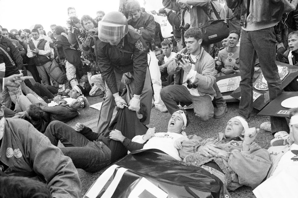 A photograph of a police officer and ACT UP protesters at the FDA headquarters in 1988.